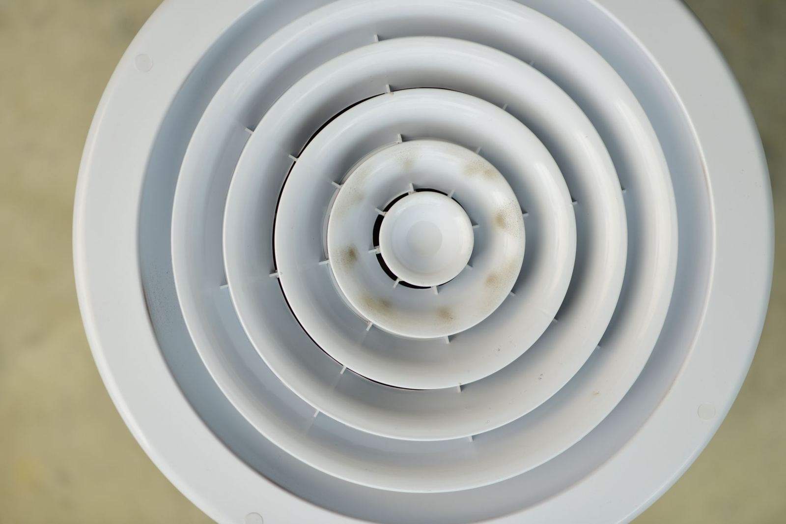 Round ceiling air register that delivers central air to a room