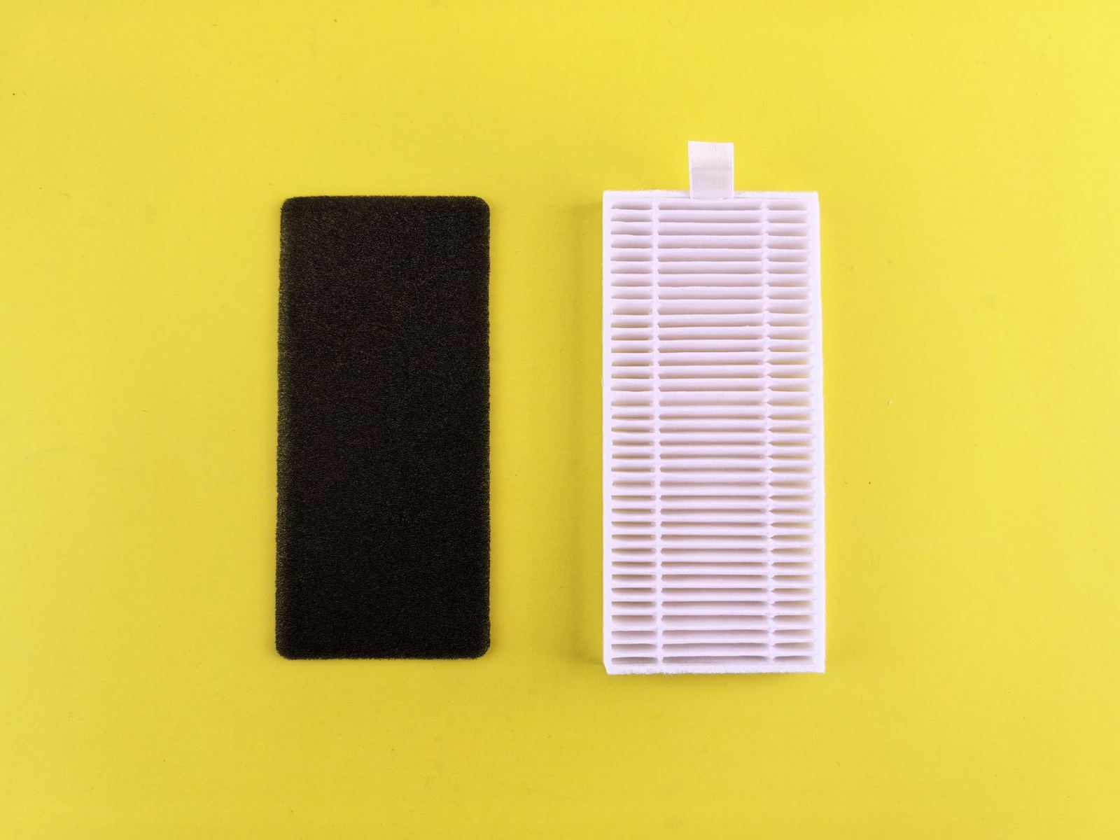 Small pleated air filter beside a foam filter