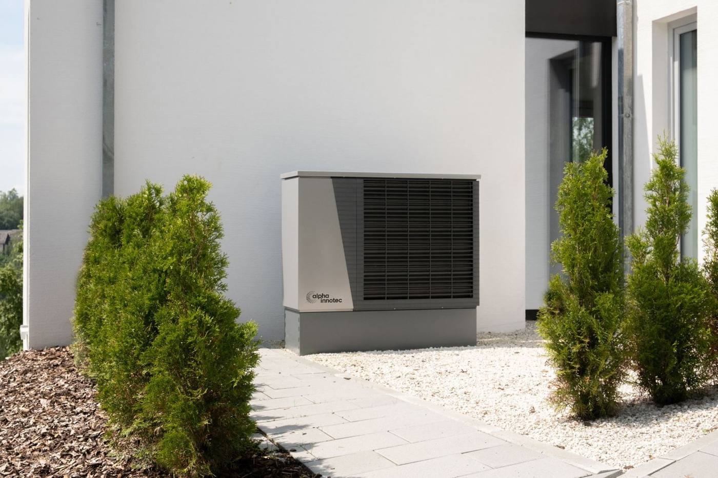 Outdoor heat pump unit next to a home in winter
