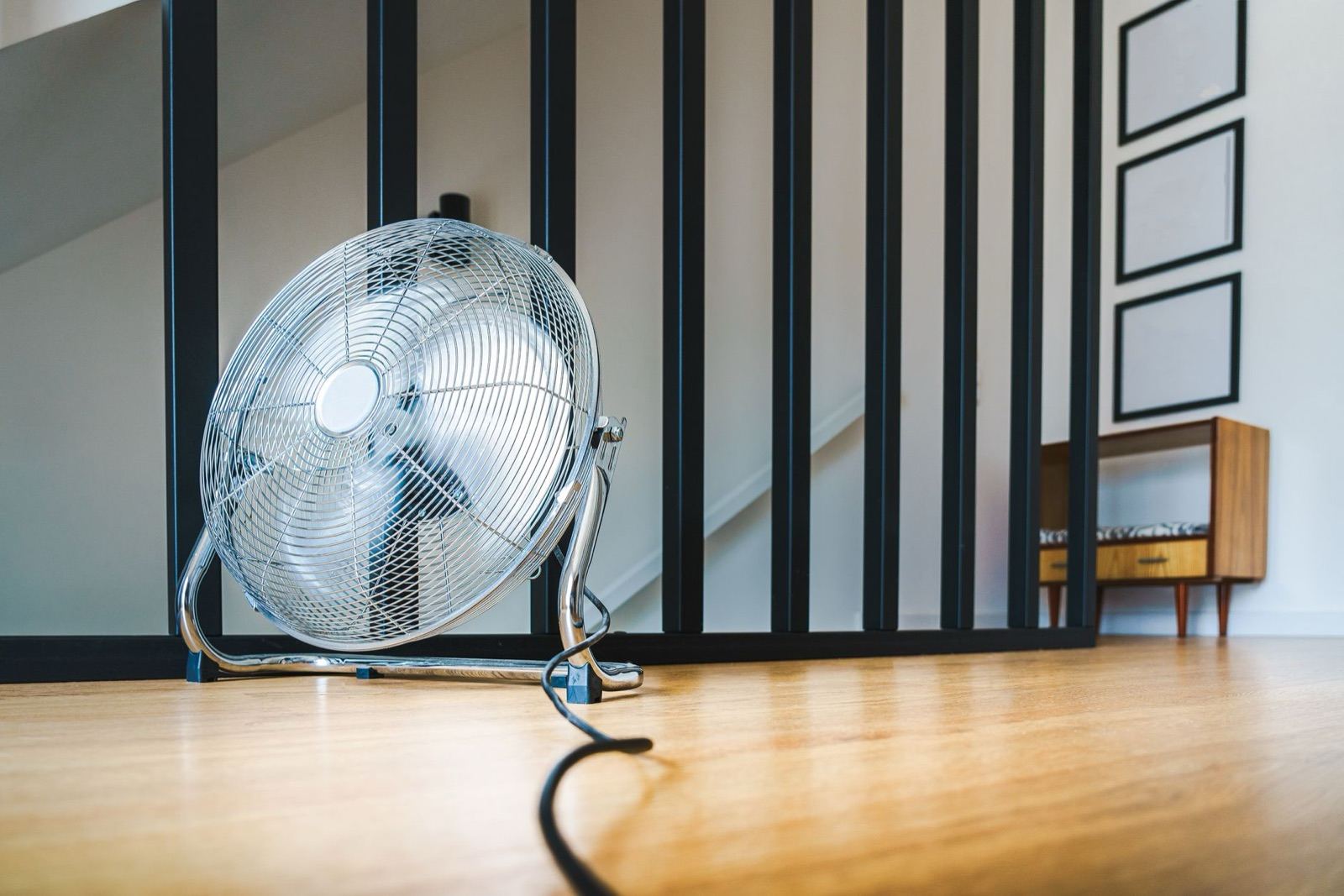Portable fan beside a window