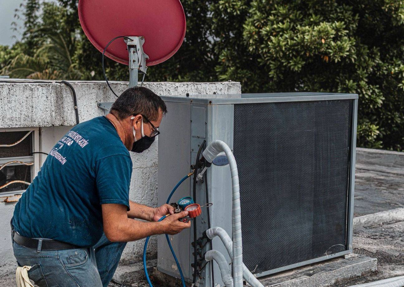 Technician checking connections on outdoor cooling equipment