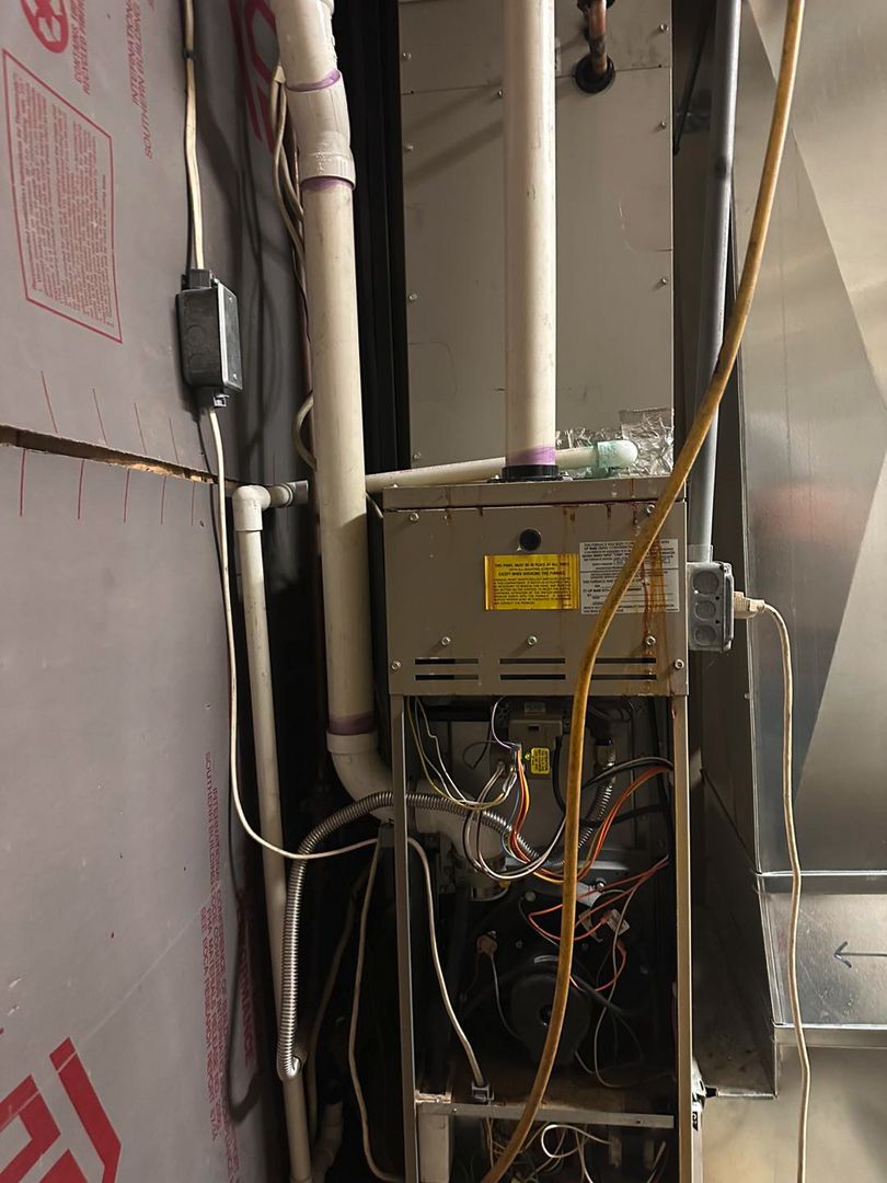 Old furnace with open cabinet and exposed wiring before replacement